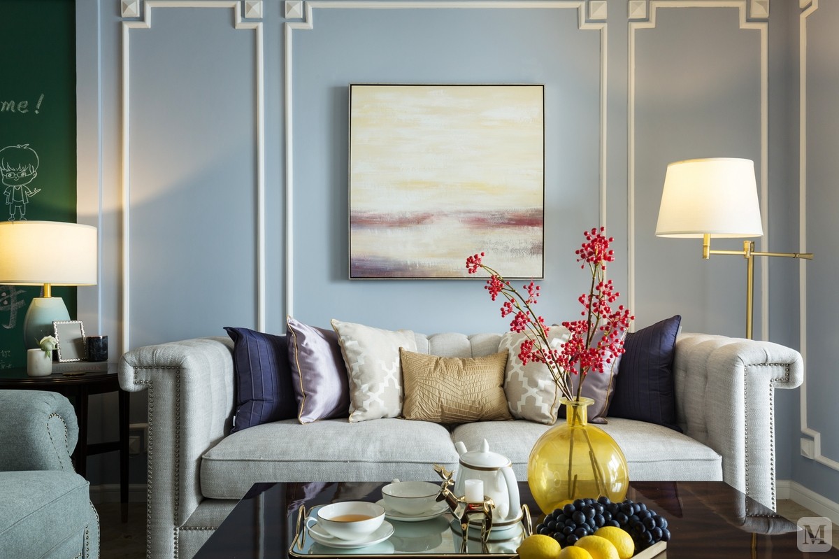 客厅顶面使用一圈蓝紫色增加整个空间的层次感，与墙面的雪纺蓝过渡自然。让整个客厅清新、淡雅富有情调。沙发背景墙使用石膏装饰线条，装饰意味浓重。沙发上的淡紫色抱枕与墙面挂画相互呼应。