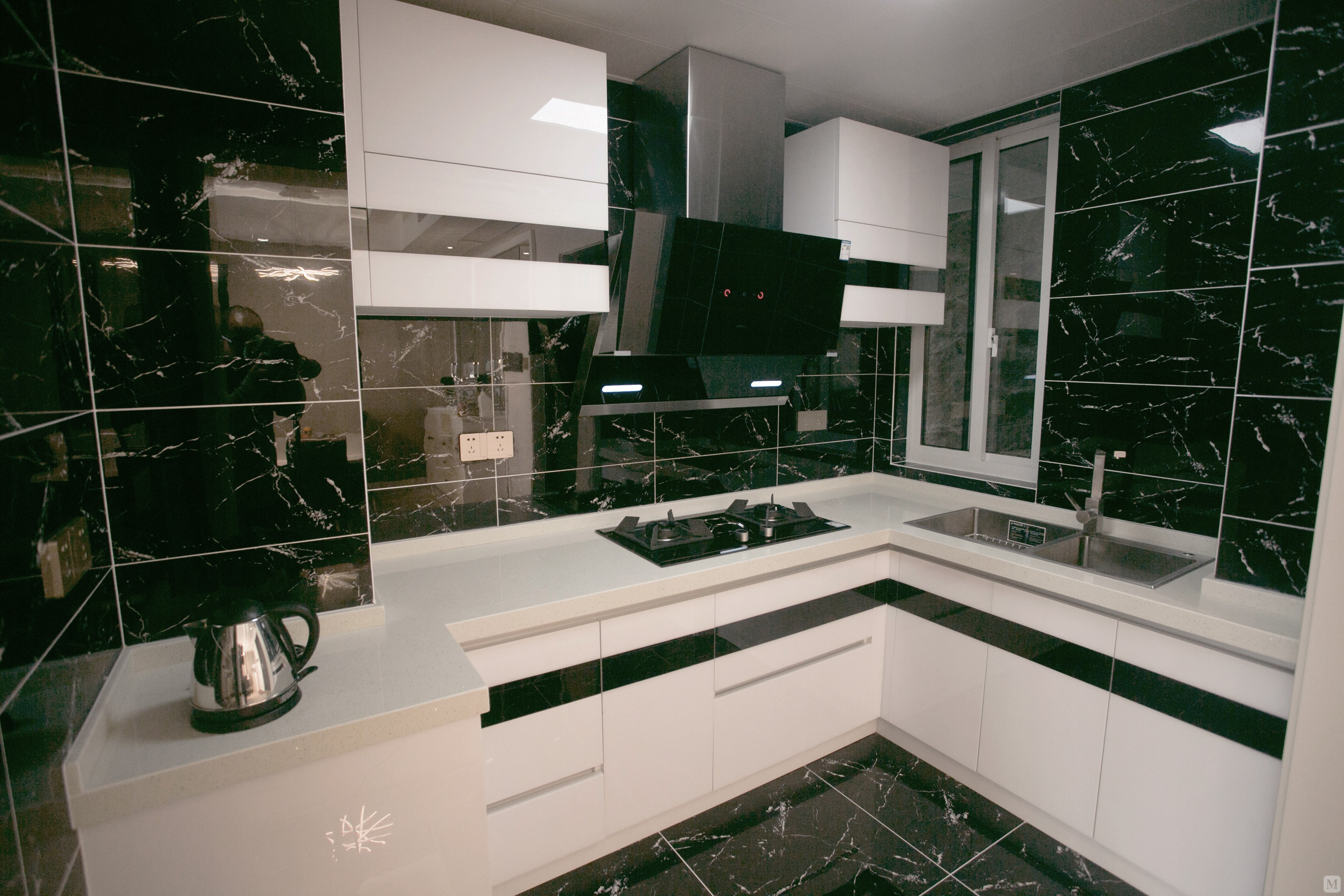 厨房依然延续了现代黑白灰风格,黑色大理石墙面搭配白色橱柜,非常具有