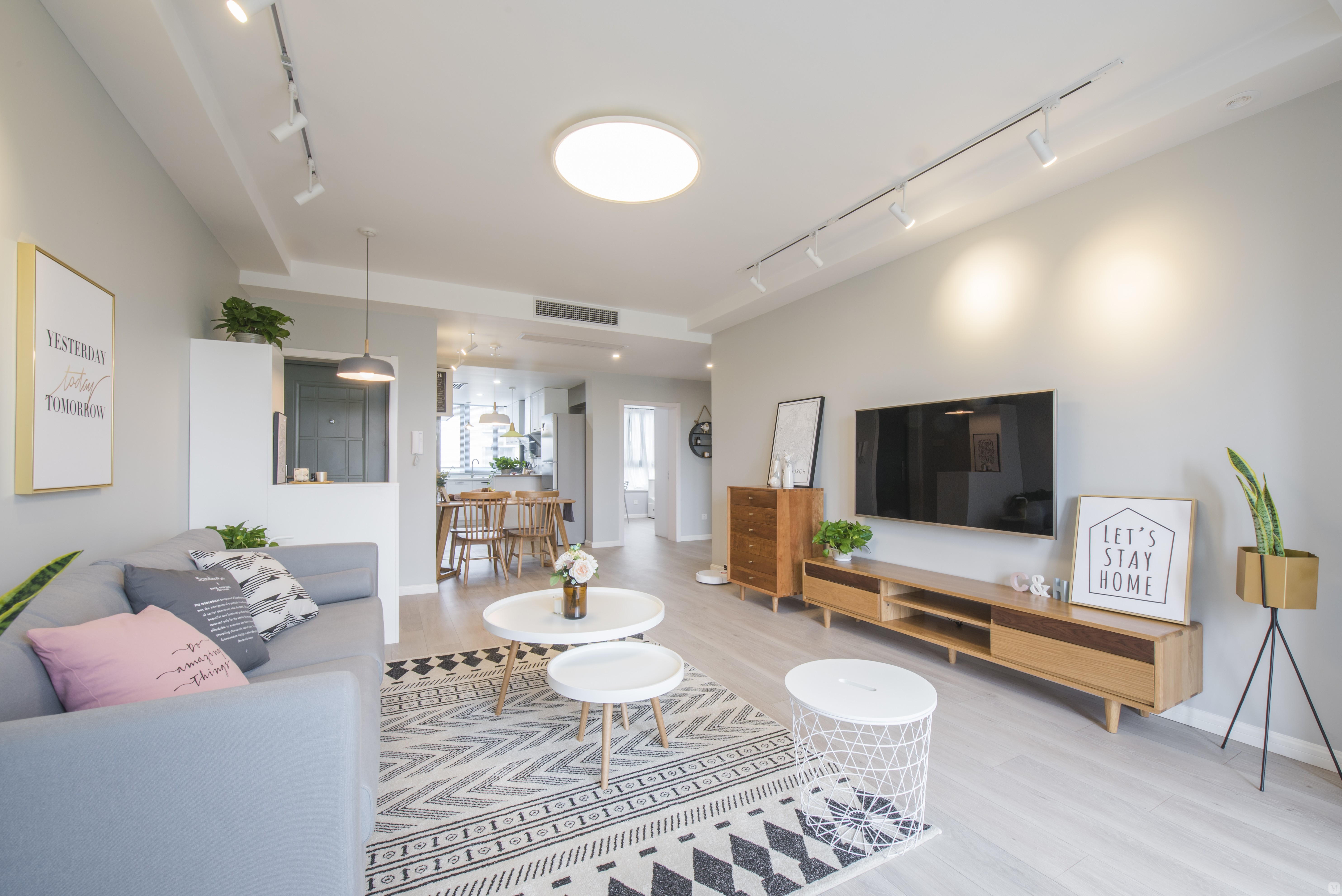 客厅区域整体的硬装设计主要是以浅灰色为主色调家具主要以原木的白色