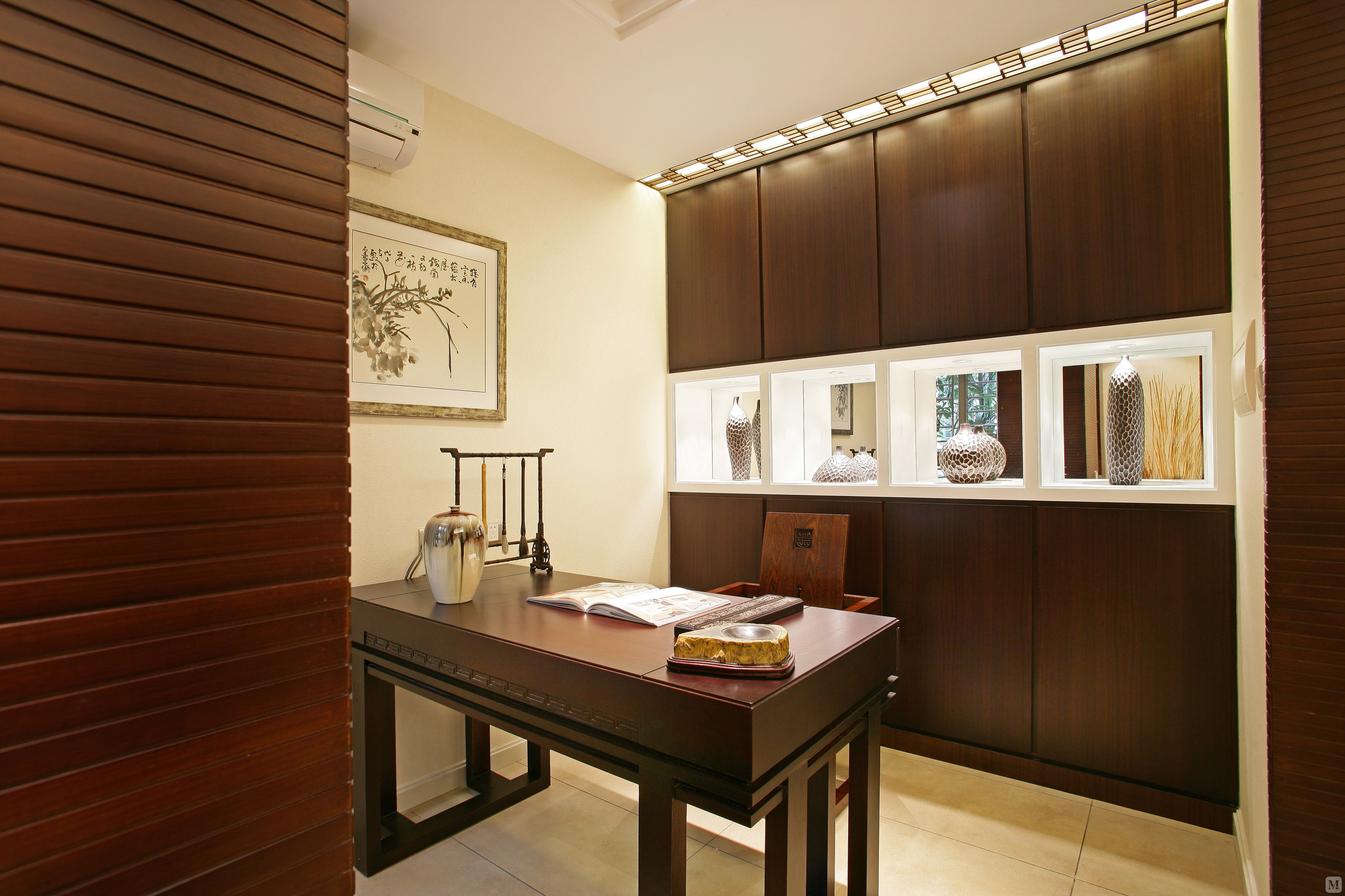 墙上挂着的水墨画颇具中国风味道,木质沙发与桌椅中式古典,圆形吊灯