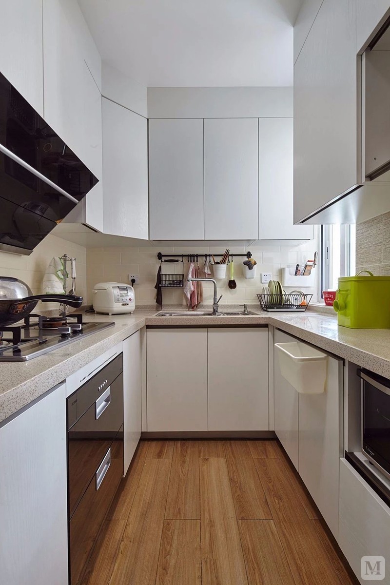 厨房在木纹砖地面基础,搭配白色的橱柜,现在文艺而精致,而u形的操作台